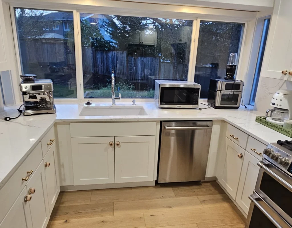 Modern kitchen with white cabinetry and wood flooring