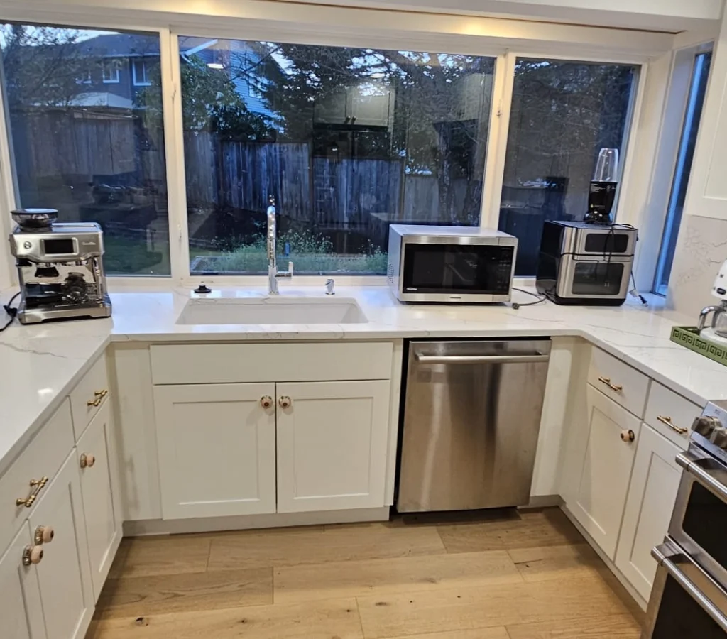 Modern kitchen with white cabinetry and wood flooring